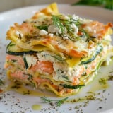 Plat de lasagnes revisitées aux courgettes et au saumon, avec une touche de chèvre et d’aneth, servi dans une belle assiette blanche.