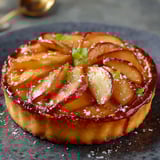 Une tartelettes de pommes est servie sur un plateau.