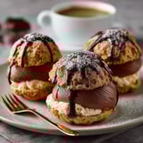 Choux Tout, une recette de desserts chocolat et crème, est servie sur un plateau avec des baguettes de chocolat et des crêpes.