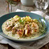 Une assiette de aiguillettes de poulet est servie sur une table avec une salade et une sauce.
