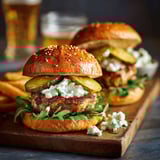 Les deux burgers morue sont sur une planche de bois.