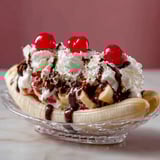 Une banana split garnie de cerises et de chocolat.