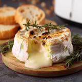Une tarte au fromage ultra-sucrée, garnie de herbes et de pain grillé, est servie sur un plateau.