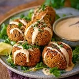 Plate of falafels with a bowl of sauce.