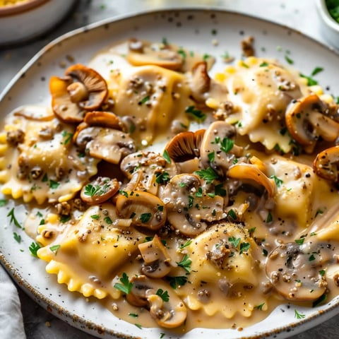 Ravioles nappées de sauce veloutée avec des champignons, le tout garni de persil frais et une touche de poivre noir.