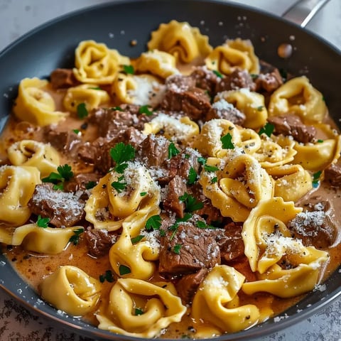 Assiette de pâtes avec viande tendre, crème au parmesan et persil frais.