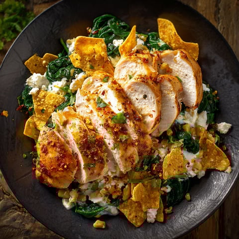 Une salade de poulet avec des chips de tortilla.
