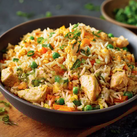 Riz frit avec des légumes et des carrés de poulet.